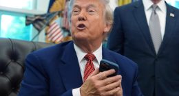 President Donald Trump silences his ringing cell phone.