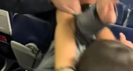 A woman in a red hat assaulting another woman on an airplane.