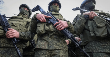 Soldiers in camouflage uniforms holding rifles.