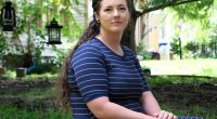 Portrait of Brittnee Nelson, a house cleaning business owner, sitting outdoors.