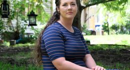 Portrait of Brittnee Nelson, a house cleaning business owner, sitting outdoors.
