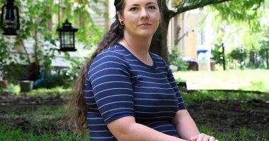 Portrait of Brittnee Nelson, a house cleaning business owner, sitting outdoors.