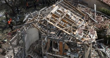 Emergency personnel at a destroyed building after a missile strike.