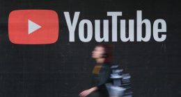 A young woman wearing headphones walks past a billboard advertisement for YouTube on September 27, 2019 in Berlin, Germany. YouTube has evolved as the world's largest platform for sharing video clips. (Photo by Sean Gallup/Getty Images)