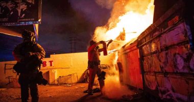A law enforcement officer works to put out a fire during a protest in Compton, Calif., Saturday, June 7, 2025, after federal immigration authorities conducted operations.