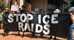 protesters holding a banner reading STOP ICE RAIDS