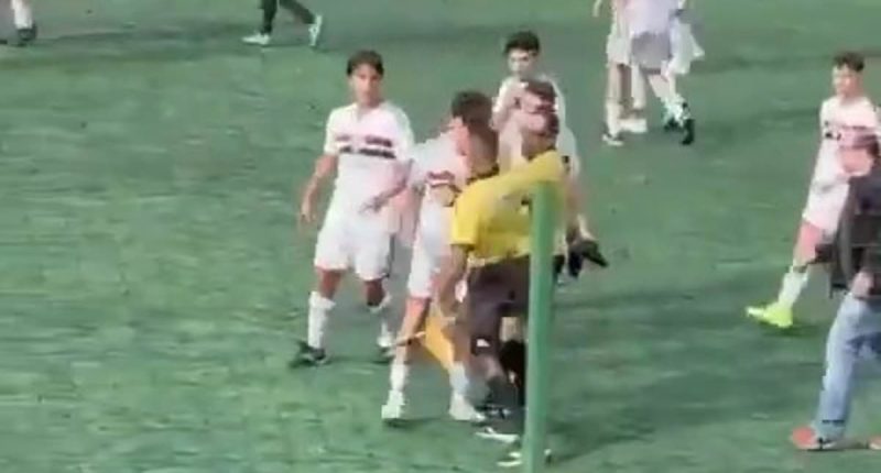 Incredible scenes as Brazilian football match descends into mass brawl with Military Police called after linesman lashed out at teenage player