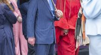 King Charles attempted to keep himself dry in the typical British wet weather by holding up a large brolly as he strolled through the streets of Shoreditch