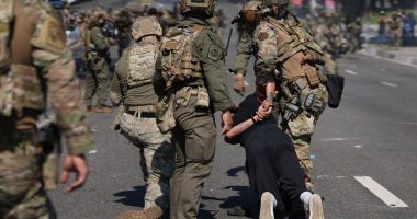 Police detain a man during a protest