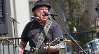 Neil Young's 'awkwardness' has gone down 'very badly' behind-the-scenes at Glastonbury, insiders tell KATIE HIND, as they reveal why his Hollywood bombshell wife Daryl Hannah is expected to skip the festival