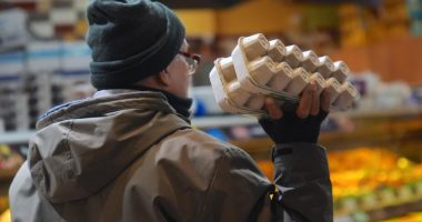 Person holding a carton of eggs in a supermarket.