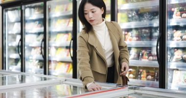 Woman shopping for frozen food in a supermarket.