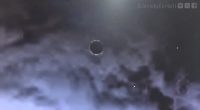 Disc-shaped object in cloudy sky.