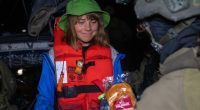 Greta Thunberg, wearing a life vest, receives food from an Israeli Defense Forces soldier after her ship was boarded.