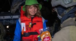 Greta Thunberg, wearing a life vest, receives food from an Israeli Defense Forces soldier after her ship was boarded.