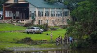 Officials search on the grounds of Camp Mystic on Sunday in Hunt, Texas.