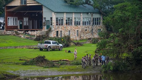 Officials search on the grounds of Camp Mystic on Sunday in Hunt, Texas.
