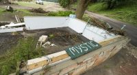 A Camp Mystic sign is seen near the entrance to the establishment along the banks of the Guadalupe River after a flash flood swept through the area in Hunt, Texas, Saturday, July 5, 2025. (AP Photo/Julio Cortez)