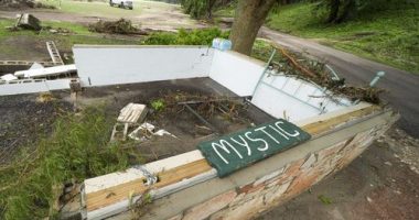A Camp Mystic sign is seen near the entrance to the establishment along the banks of the Guadalupe River after a flash flood swept through the area in Hunt, Texas, Saturday, July 5, 2025. (AP Photo/Julio Cortez)