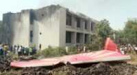 Debris from a plane crash near a building.