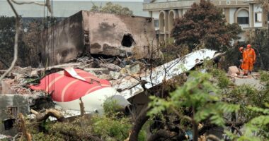 Debris from a plane crash site with rescue workers.