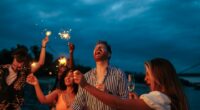 Group of friends celebrating with sparklers and drinks at night.