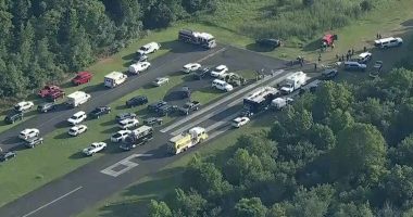 Aerial view of emergency personnel and vehicles at an airport runway after a small aircraft crash.