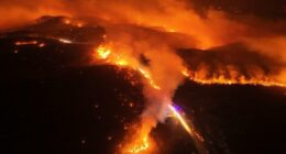 Aerial view of a large wildfire at night.