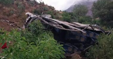Wrecked bus on a hillside.