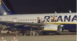 Passengers evacuating a Ryanair plane on the tarmac.