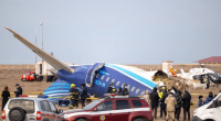 Plane crash at an airport with emergency personnel and onlookers.
