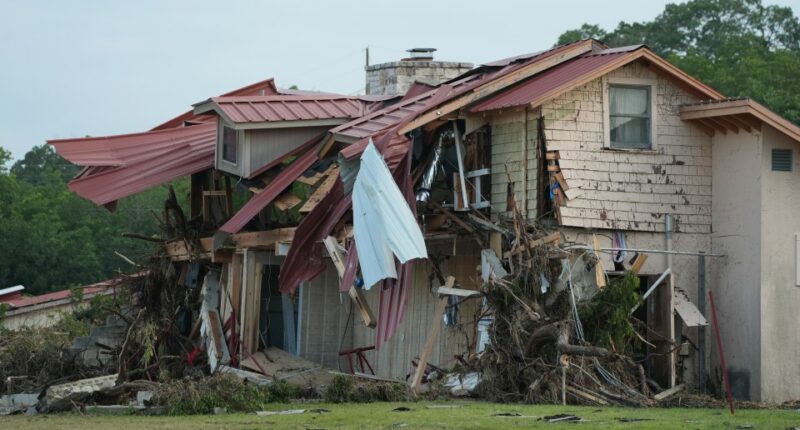 Flood-damaged building with its roof torn off.