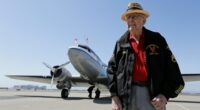 A D-Day veteran and a pilot holding hands.