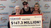 Kentucky Powerball jackpot winners holding a $167.3 million check.