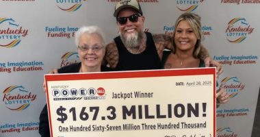 Kentucky Powerball jackpot winners holding a $167.3 million check.