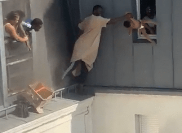 Man catching baby dropped from window.