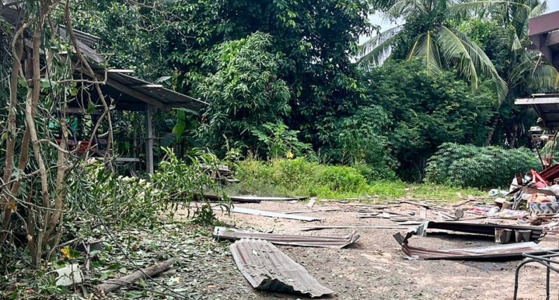 Debris from a rocket strike damaging a house.