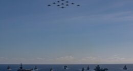 Aerial view of multiple warships sailing in formation.