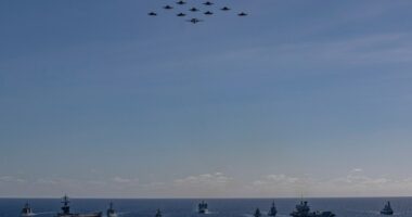Aerial view of multiple warships sailing in formation.