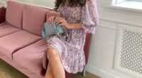 Woman in floral dress sitting on a pink couch.