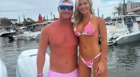 Couple in swimwear posing on a boat.