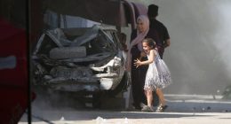 A Palestinian mother and her daughter rush for cover during an Israeli strike at a refugee camp in the central Gaza Strip on July 4 2025