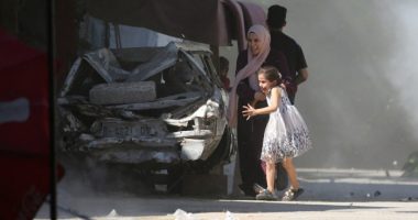 A Palestinian mother and her daughter rush for cover during an Israeli strike at a refugee camp in the central Gaza Strip on July 4 2025