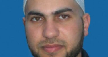 Headshot of a man wearing a kufi.