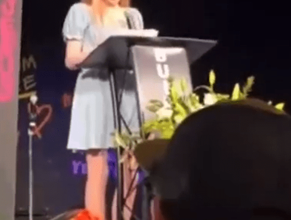 Woman giving a speech at a podium.