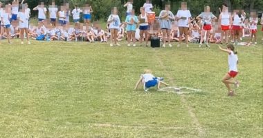 A girl falling during a field day event while other girls watch.