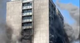 High-rise building engulfed in smoke and fire.