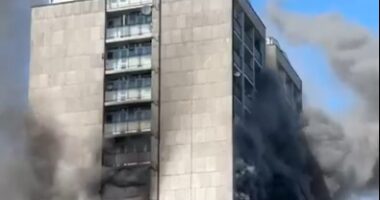 High-rise building engulfed in smoke and fire.
