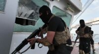 Armed men in black tactical gear aboard a ship.