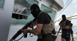 Armed men in black tactical gear aboard a ship.